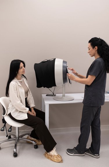 Дерматолог проводить комп’ютерну діагностику шкіри обличчя