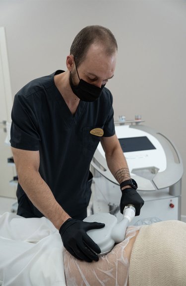 Косметолог проводить процедуру кріоліполізу для корекції фігури