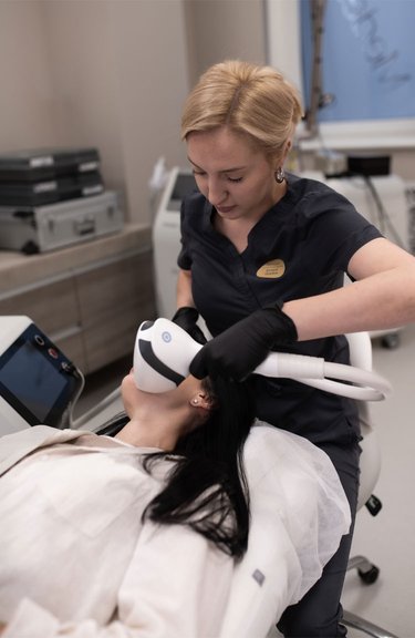 Косметолог проводить фототерапію для лікування акне та постакне